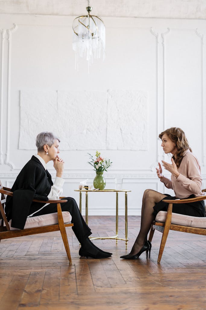 Two women talking during a counseling session in a bright office